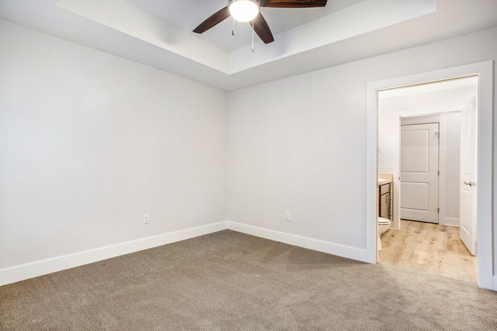 A carpeted bedroom with bathroom