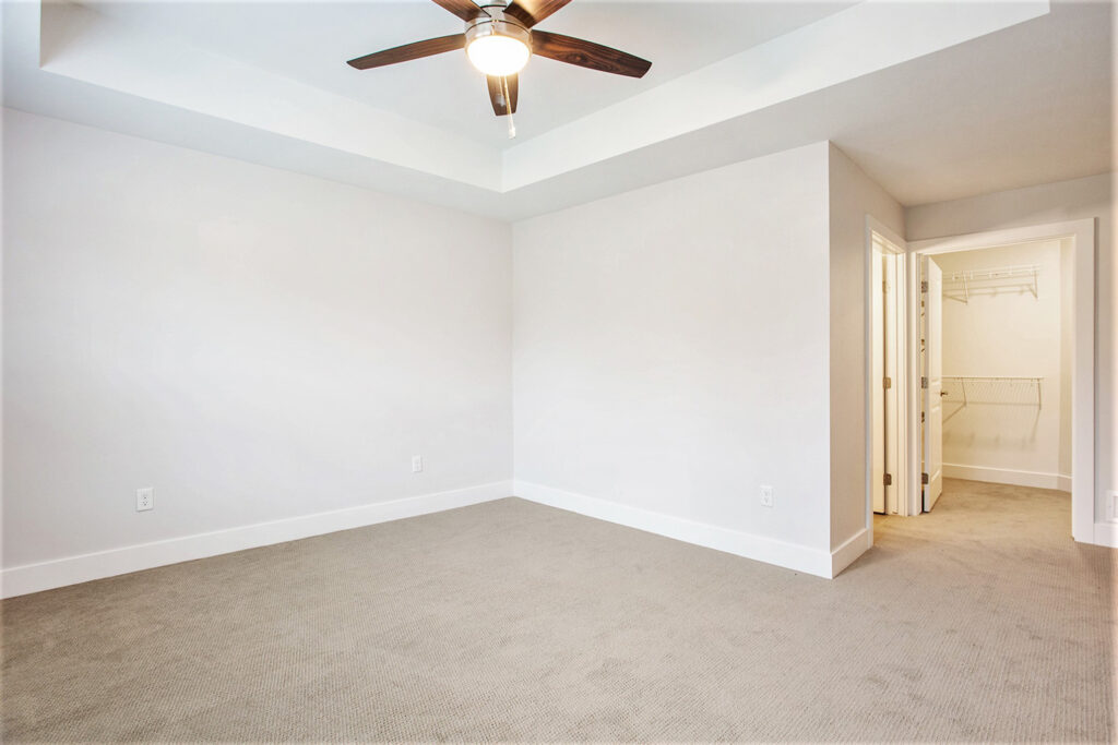 Carpeted bedroom with walk in closet and bathroom